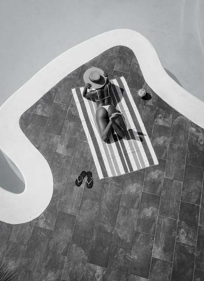 Mulher tomando sol à beira da piscina